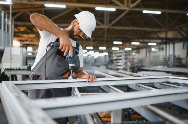 Pencere ve kapılar için çerçeve yapan PVC işçisi veya operatörü.