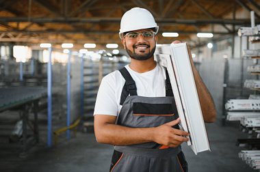 Makine operatörü. Fabrikada sanayi işçisi. Beyaz şapkalı genç teknisyen..