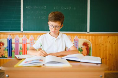 Masada, sınıfta oturan mutlu öğrenci..