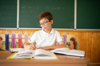 Masada, sınıfta oturan mutlu öğrenci..