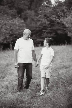 Mutlu büyükbaba ve torunun sonbahar parkındaki portresi..