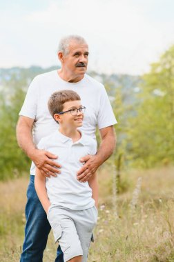 İyi hafta sonları. Mutlu büyükbaba ve torun parkta yürüyor..