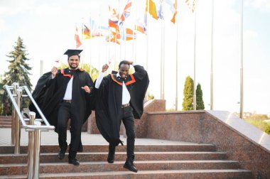 İki arkadaş üniversite mezunudur. Hintli ve Afrikalı mezunlar.
