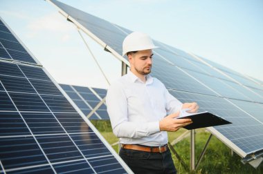Gözlüklü erkek mühendis ve güneş panellerinin resmi beyaz gömlek izleme sistemi.