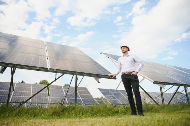 Gözlüklü erkek mühendis ve güneş panellerinin resmi beyaz gömlek izleme sistemi.