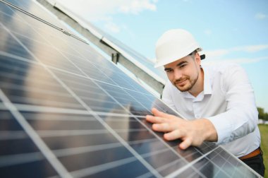 Güneş çiftliği, mühendis ile güneş paneli sistemin işleyişini kontrol eder, dünyanın enerjisini korumak için alternatif enerji, temiz enerji üretimi için fotovoltaik modül fikri.