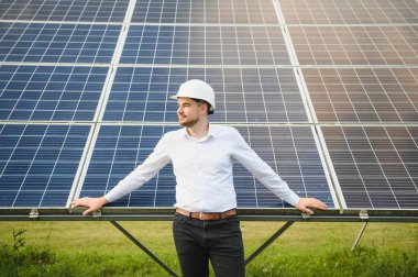 Güneş çiftliği, mühendis ile güneş paneli sistemin işleyişini kontrol eder, dünyanın enerjisini korumak için alternatif enerji, temiz enerji üretimi için fotovoltaik modül fikri.