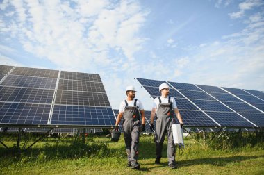 Güneş panelleri kuran iki işçi.