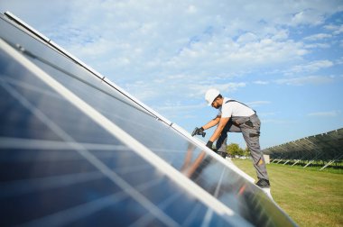 Hintli işçi güneş panelleri kuruyor. Alternatif, yenilenebilir enerji kavramı.