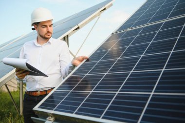 Gözlüklü erkek mühendis ve güneş panellerinin resmi beyaz gömlek izleme sistemi.