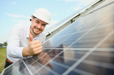 Güneş çiftliği, mühendis ile güneş paneli sistemin işleyişini kontrol eder, dünyanın enerjisini korumak için alternatif enerji, temiz enerji üretimi için fotovoltaik modül fikri.