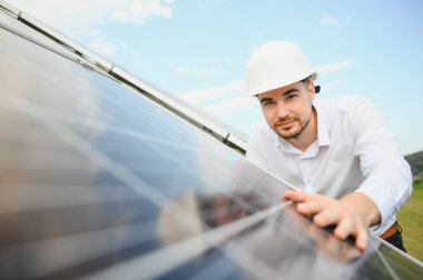 Gözlüklü erkek mühendis ve güneş panellerinin resmi beyaz gömlek izleme sistemi.