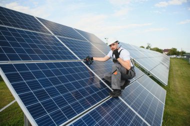 Dışarıda güneş panelleri kuran işçiler.