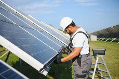 Hintli işçi güneş panelleri kuruyor. Alternatif, yenilenebilir enerji kavramı.
