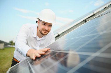 Güneş çiftliği, mühendis ile güneş paneli sistemin işleyişini kontrol eder, dünyanın enerjisini korumak için alternatif enerji, temiz enerji üretimi için fotovoltaik modül fikri.