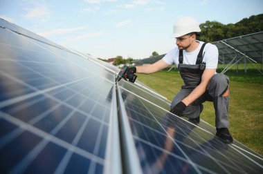 Dışarıda güneş panelleri kuran işçiler.