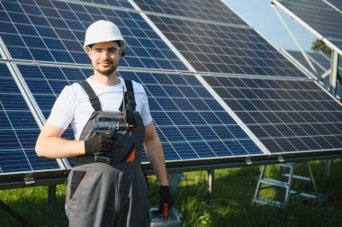 Dışarıda güneş panelleri kuran işçiler.