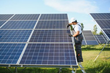 Hintli işçi güneş panelleri kuruyor. Alternatif, yenilenebilir enerji kavramı.