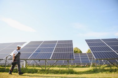 Tornavidalı Hintli işçi güneş panelleri üzerinde çalışıyor. Yenilenebilir enerji.