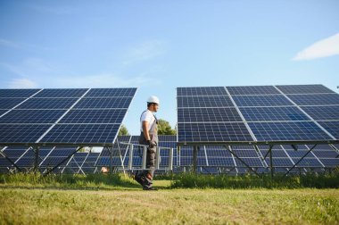 Hintli işçi güneş panelleri kuruyor. Alternatif, yenilenebilir enerji kavramı.