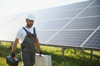 Hintli işçi güneş panelleri kuruyor. Alternatif, yenilenebilir enerji kavramı.