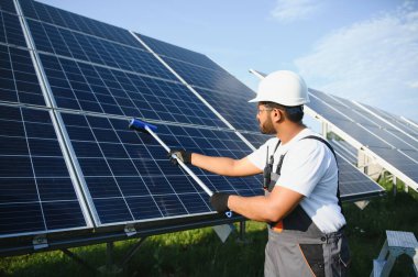 Hintli tamirci güneş panellerini temizleyip toz ve kir oluşturuyor..