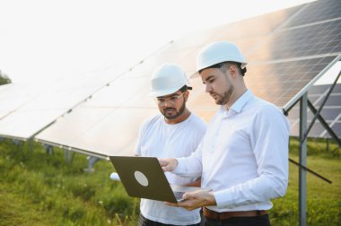 Hintli mühendis ve işadamı yeni ekoloji projesi planlıyorlar. Güneş paneli çatısı etrafında.