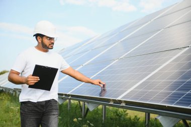 Güneş panelleri alanında çalışan genç bir Hintli erkek mühendisin portresi.