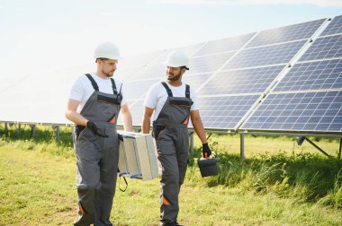 Güneş enerjisi santralinde kontrol ve bakım üzerinde çalışan mühendislik ekibi güneş paneli teknisyenleri güneşli bir günde.