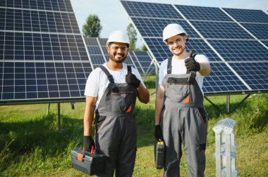 İki mühendisden oluşan bir ekip bir güneş enerjisi istasyonuna güneş panelleri kurmaya çalışıyor. Mühendis ekibi güneş pilleri kurma işini tartışıyor.