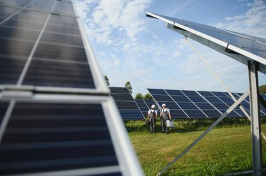 Güneş panelleri kuran iki işçi.