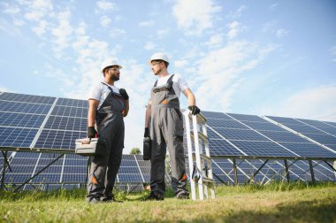 Güneş enerjisi santralinde kontrol ve bakım üzerinde çalışan mühendislik ekibi güneş paneli teknisyenleri güneşli bir günde.