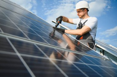 Worker installing solar panels outdoors. clipart