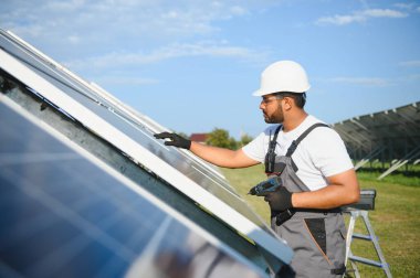 Hintli işçi güneş panelleri kuruyor. Alternatif, yenilenebilir enerji kavramı.