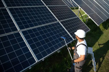 Hintli tamirci güneş panellerini temizleyip toz ve kir oluşturuyor..