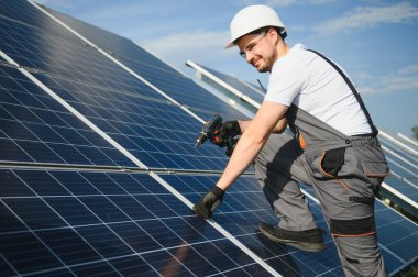 Dışarıda güneş panelleri kuran işçiler.