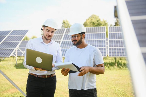 Два инженера проводят наружный осмотр солнечных фотоэлектрических панелей
.
