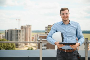 Tabletli mühendis, bina teftişi. Miğferli inşaat işçisi yeni ev inşa ediyor..