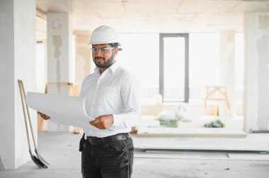 İnşaat alanında duran Asyalı mühendis kendinden emin, mühendis inşaatı başarılı ve hedef planlamada başarılı..