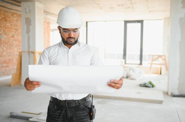 İnşaat alanında duran Asyalı mühendis kendinden emin, mühendis inşaatı başarılı ve hedef planlamada başarılı..