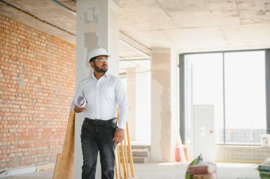 İnşaat alanında kasklı bir erkek mimar..