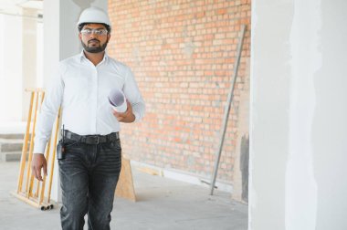 İnşaat alanında duran Asyalı mühendis kendinden emin, mühendis inşaatı başarılı ve hedef planlamada başarılı..