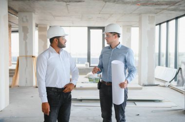 İki mimar mühendis inşa edilmiş bir ofis binasında konuşuyor..