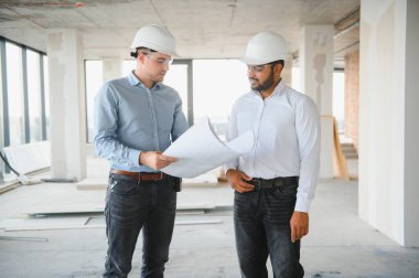 İki mimar mühendis inşa edilmiş bir ofis binasında yürüyorlar. Projenin uygulanması.