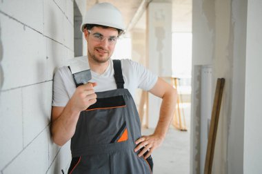 Üniformalı işçiler duvarları sıva ile kaplıyor..