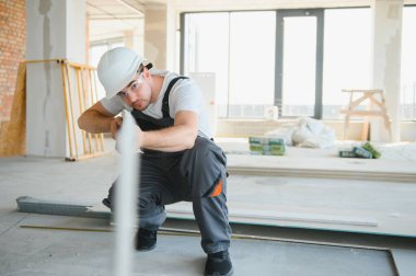 İnşaat alanında çalışırken kasketli yakışıklı bir erkek müteahhit.