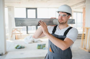 İnşaat alanındaki inşaat alanındaki kesme makinesiyle metal profili kesen çalışan bir inşaat işçisi.