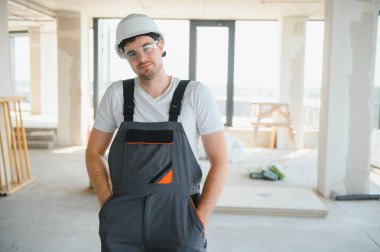 İnşaat alanında şapka takan genç bir müteahhit..