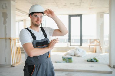 İnşaat alanında şapka takan genç bir müteahhit..