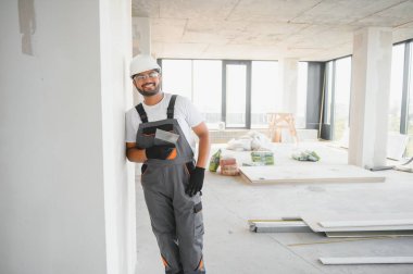 Profesyonel işçi duvarları macun bıçağıyla sıva yapıyor..